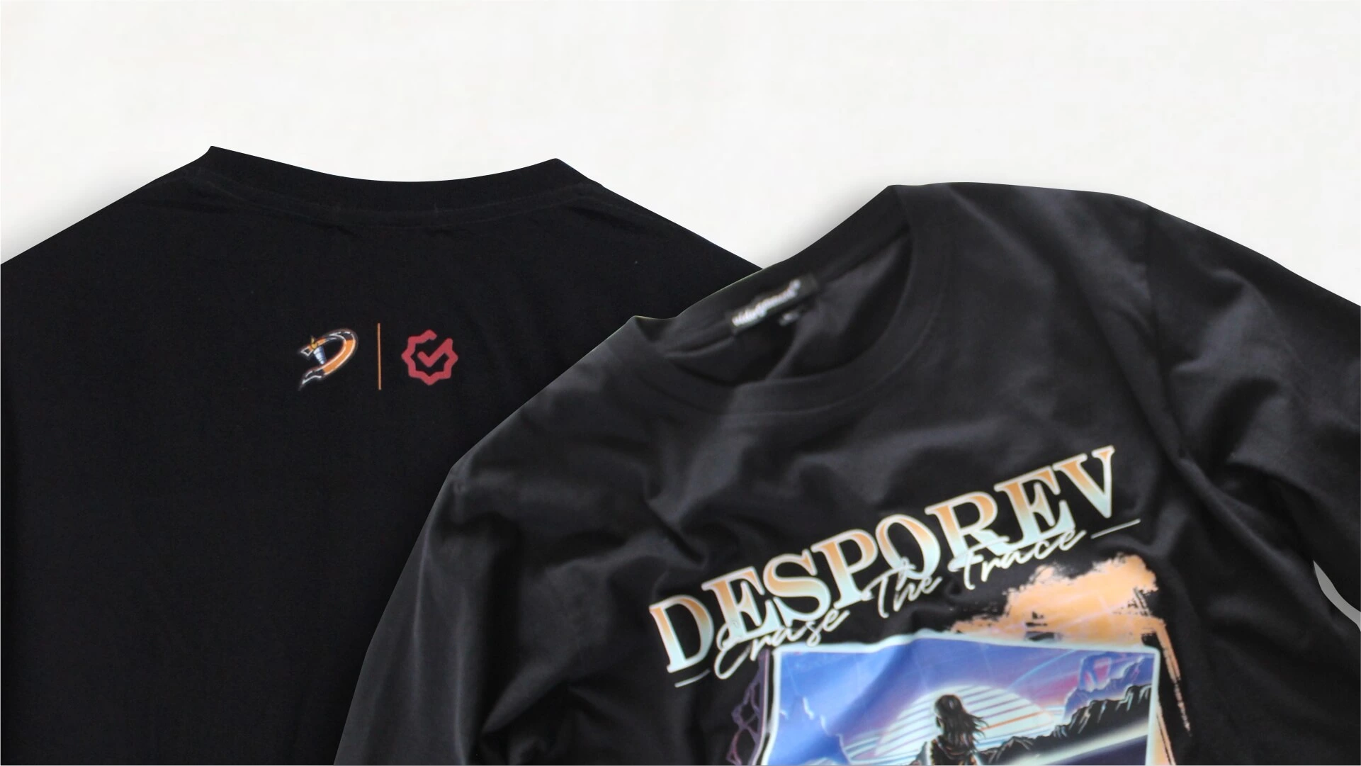 Dua kaos hitam hasil sablon bertumpuk, satu dengan cetakan grafis warna besar di dada