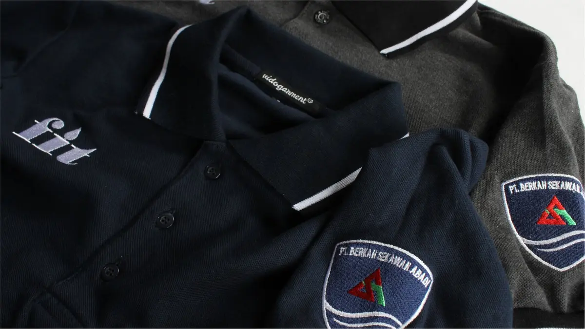Tumpukan kaos polo seragam biru navy dan abu-abu terlipat rapi
