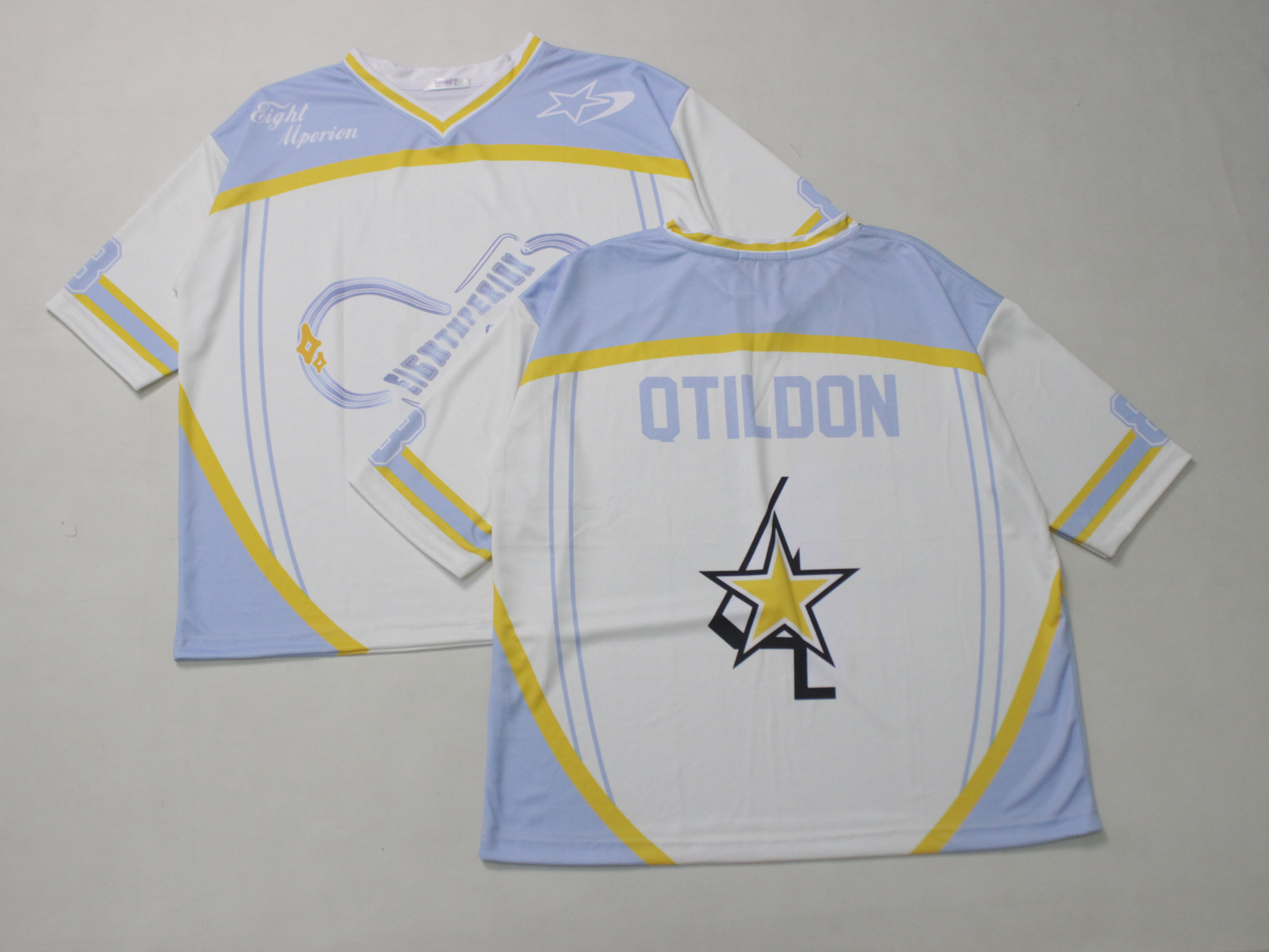 Dua jersey tim putih biru bertuliskan nama dan logo hasil sublimasi ditumpuk