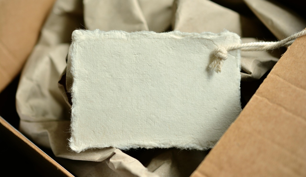 Paket berbungkus kertas dengan label bertali tergeletak di atas kertas kraft