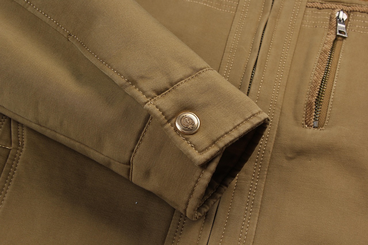 Detail manset jaket kain tan dengan rib rajut terlihat dan jahitan kontras