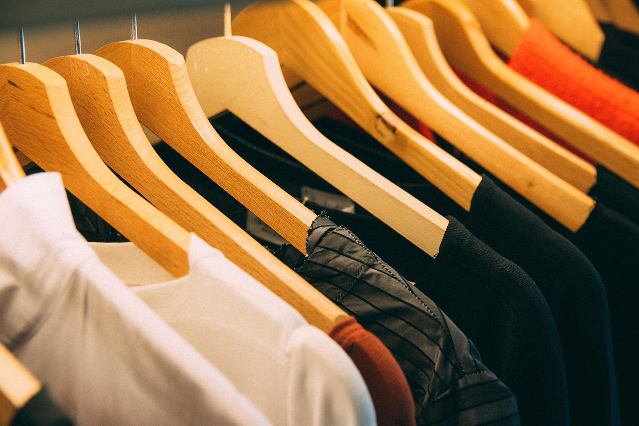 Kaos putih menggantung paling depan pada deretan hanger kayu