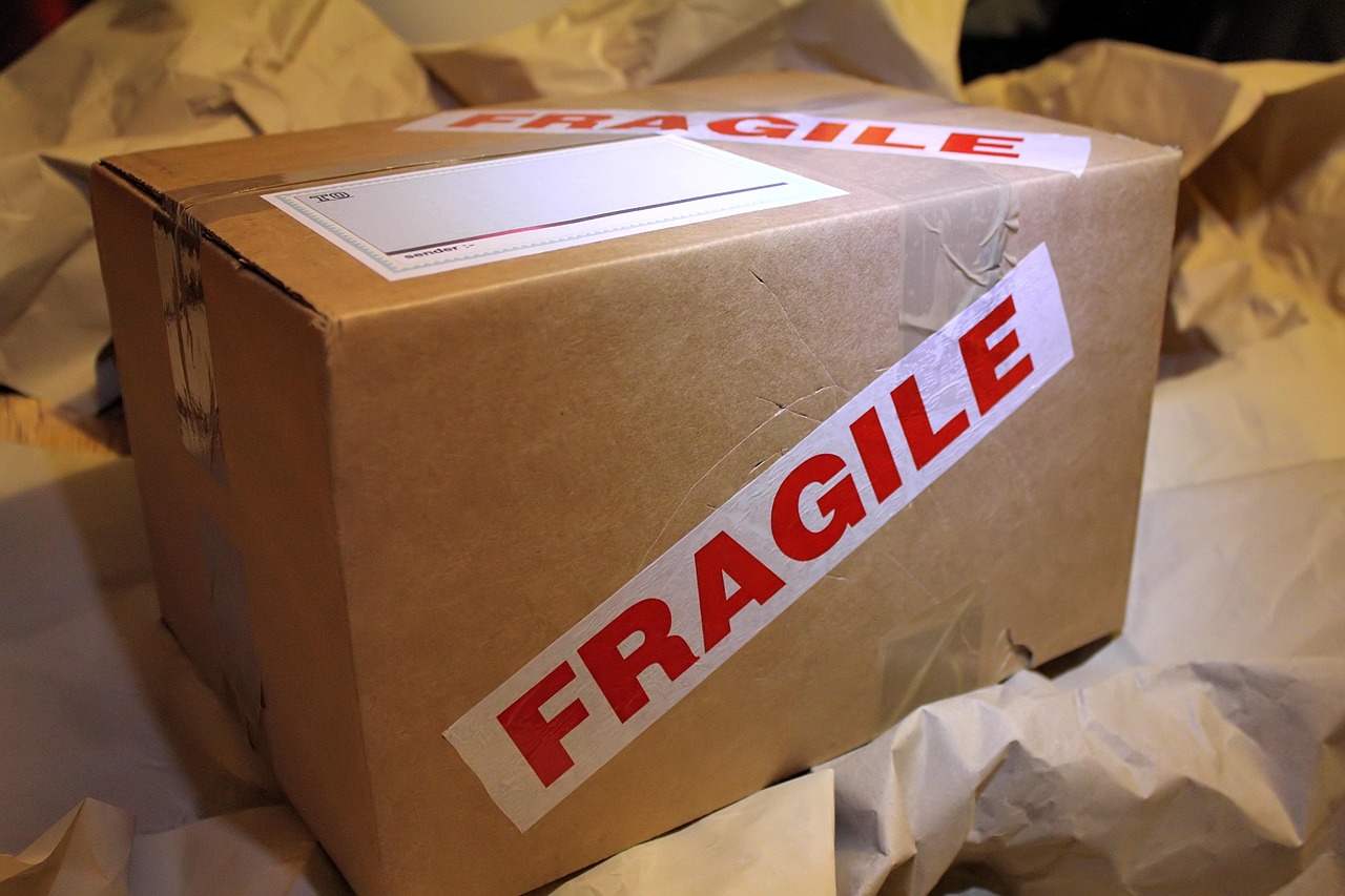 Paket kardus yang sudah disegel lakban, di atas tumpukan kertas pembungkus